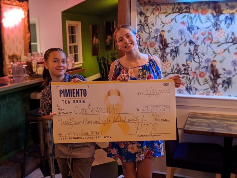 Supporters holding a donation check from a local fundraiser