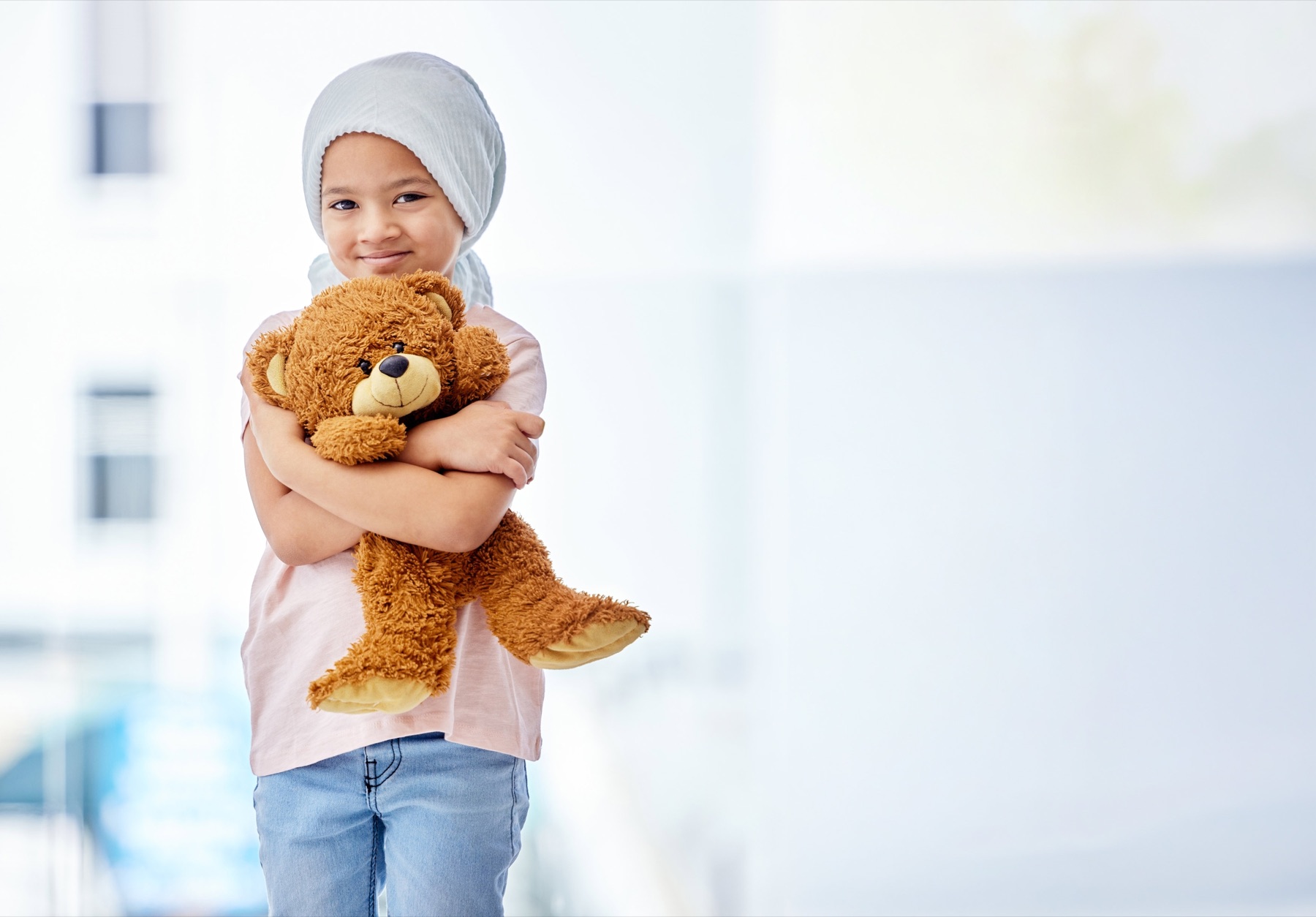 A young child in treatment holding a teddy bear