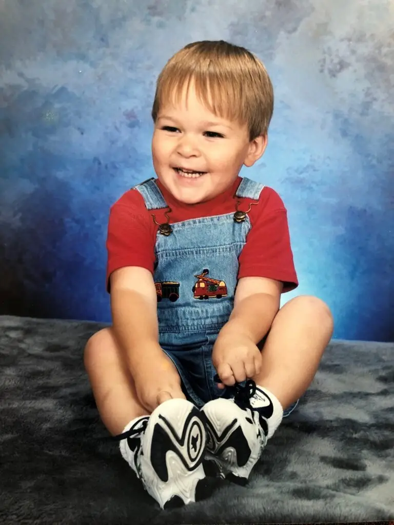 Jacob Koenigs as a smiling toddler in a studio portrait