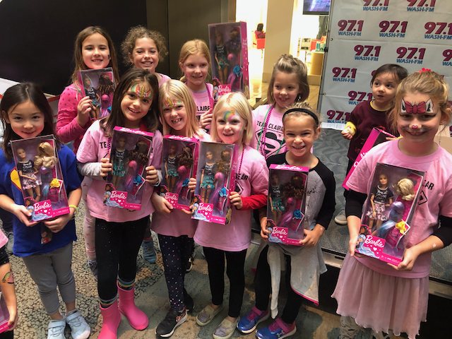 A group of children holding Brave Barbie dolls