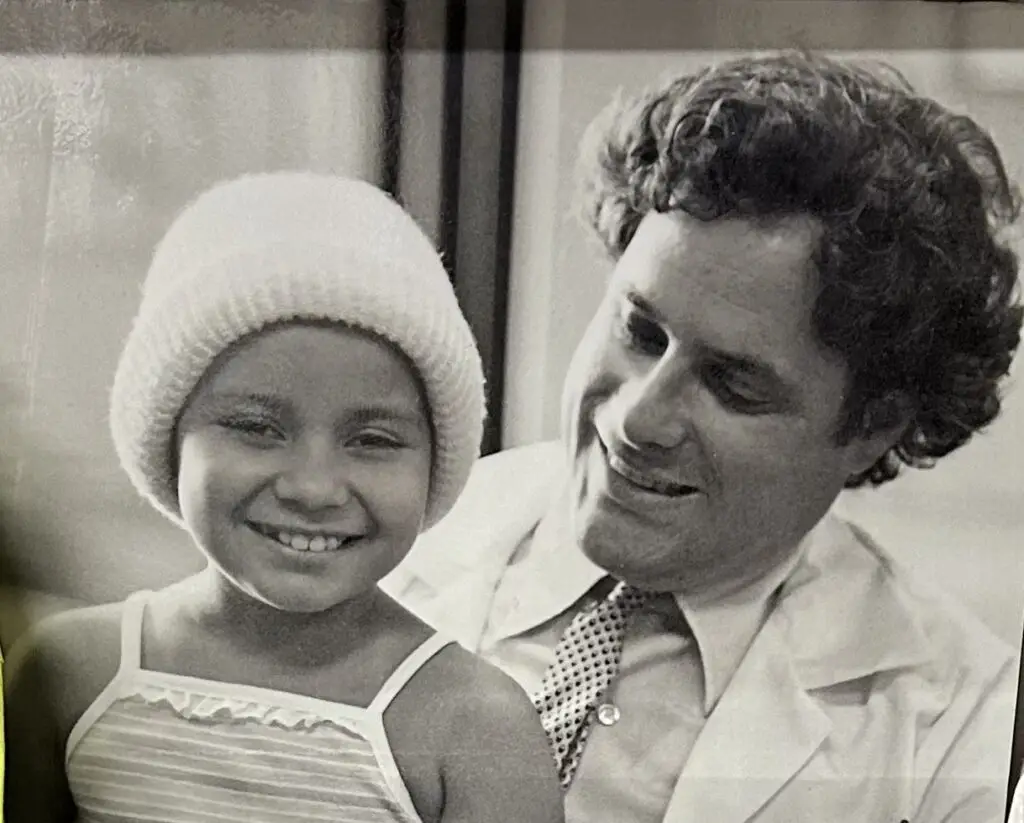 Dr. Stuart Siegel smiling with a young patient in a knit hat