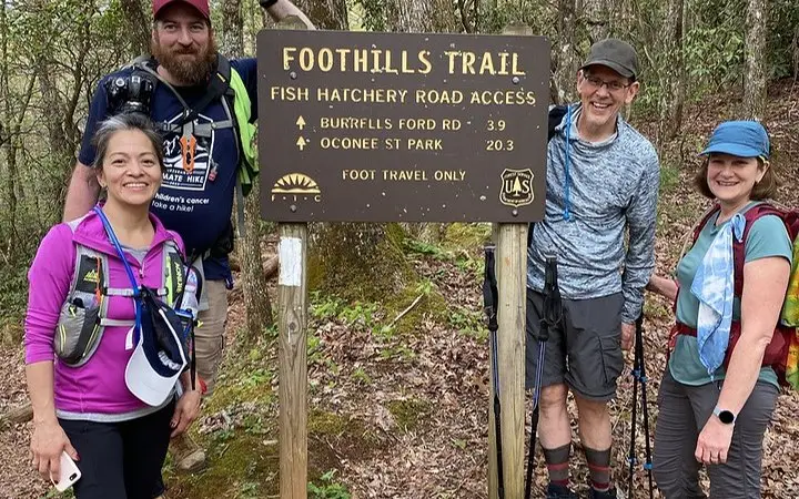 Ultimate Hike participants beside a Foothills Trail sign
