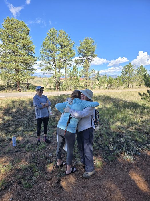 Two hikers sharing a hug on a Colorado trail