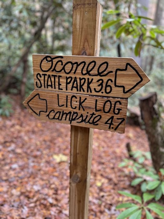 A wooden trail sign pointing to Oconee State Park