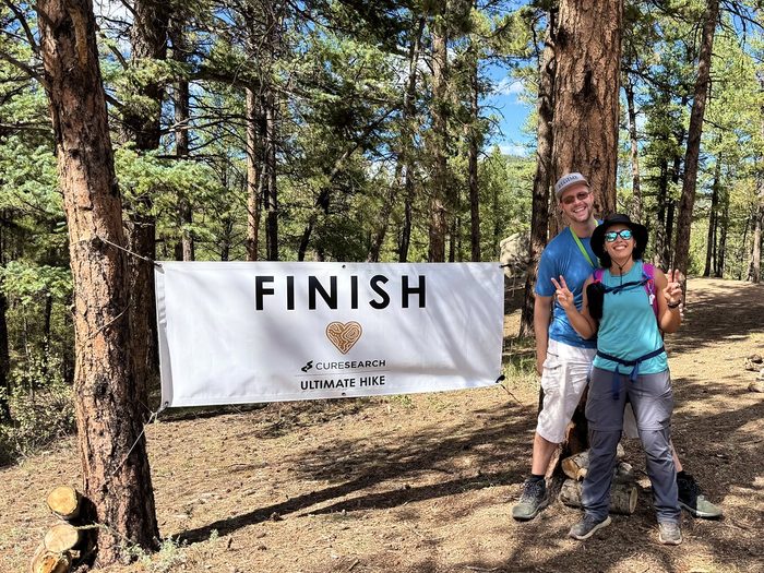 Hikers with the FINISH banner in a Colorado forest