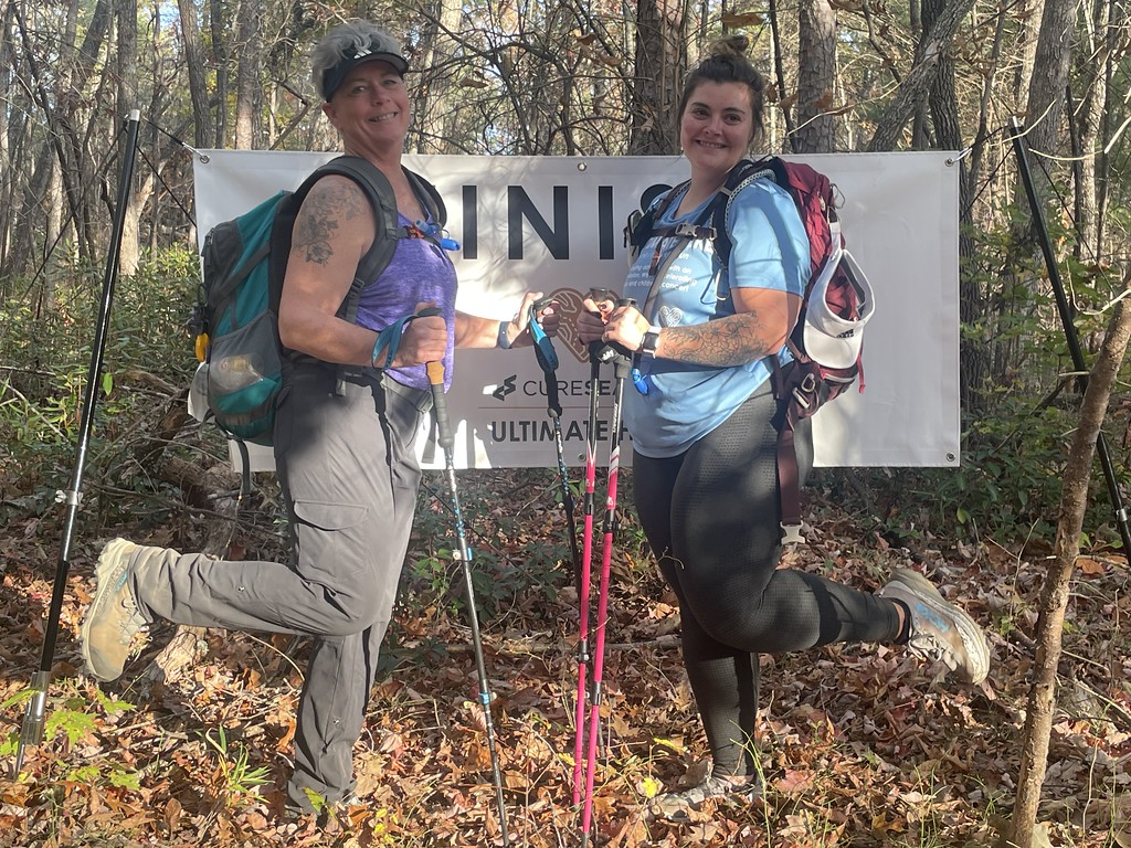 Two hikers celebrating at the Ultimate Hike finish banner