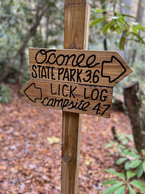 Hand-painted trail sign pointing to Oconee State Park on the Foothills Trail