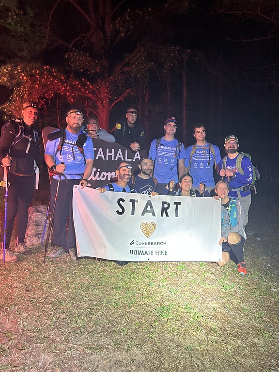 Hikers gathered at the Ultimate Hike start banner before dawn