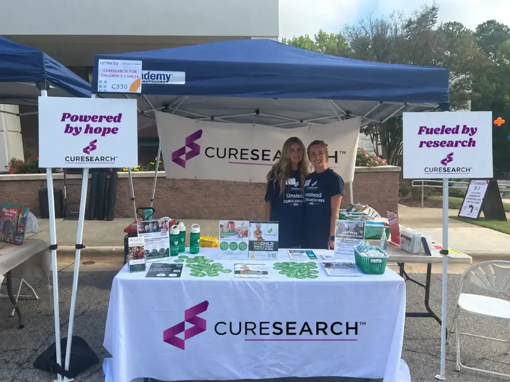 Volunteers at a CureSearch event booth